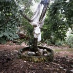 Brazil, Cachoeira, Salvador da Bahia. The sacred tree and pots outside a Candomble Terreiro (Temple) for the specific celebration of the orixa (god) Oxumare, serpent-god of the rain and the rainbow. Oxumare, or Osumare, is also the divinity of the feminine and masculine nature, who has the power to transport the water into the sky and the hearth.