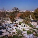 Tunisia, Tunis
A family sit around a grave at a cemetery.