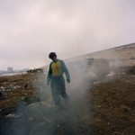 Romania, Bucharest. 
Sorin walk out of his shack surrounded by smoke.
