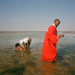 Mozambique, Maputo.
During purification rites held on a beach by adherents of a Zion church a woman is ceremonially washed while a pastor walks away to give them privacy.