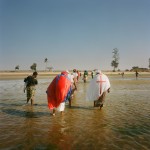 Mozambique, Maputo. Adherents from a Zion church walk back to shore together following a purification ceremony held in the sea.