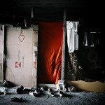 Greece, Patras. Red cloth used as a door in a shack used by Afghan refugees.